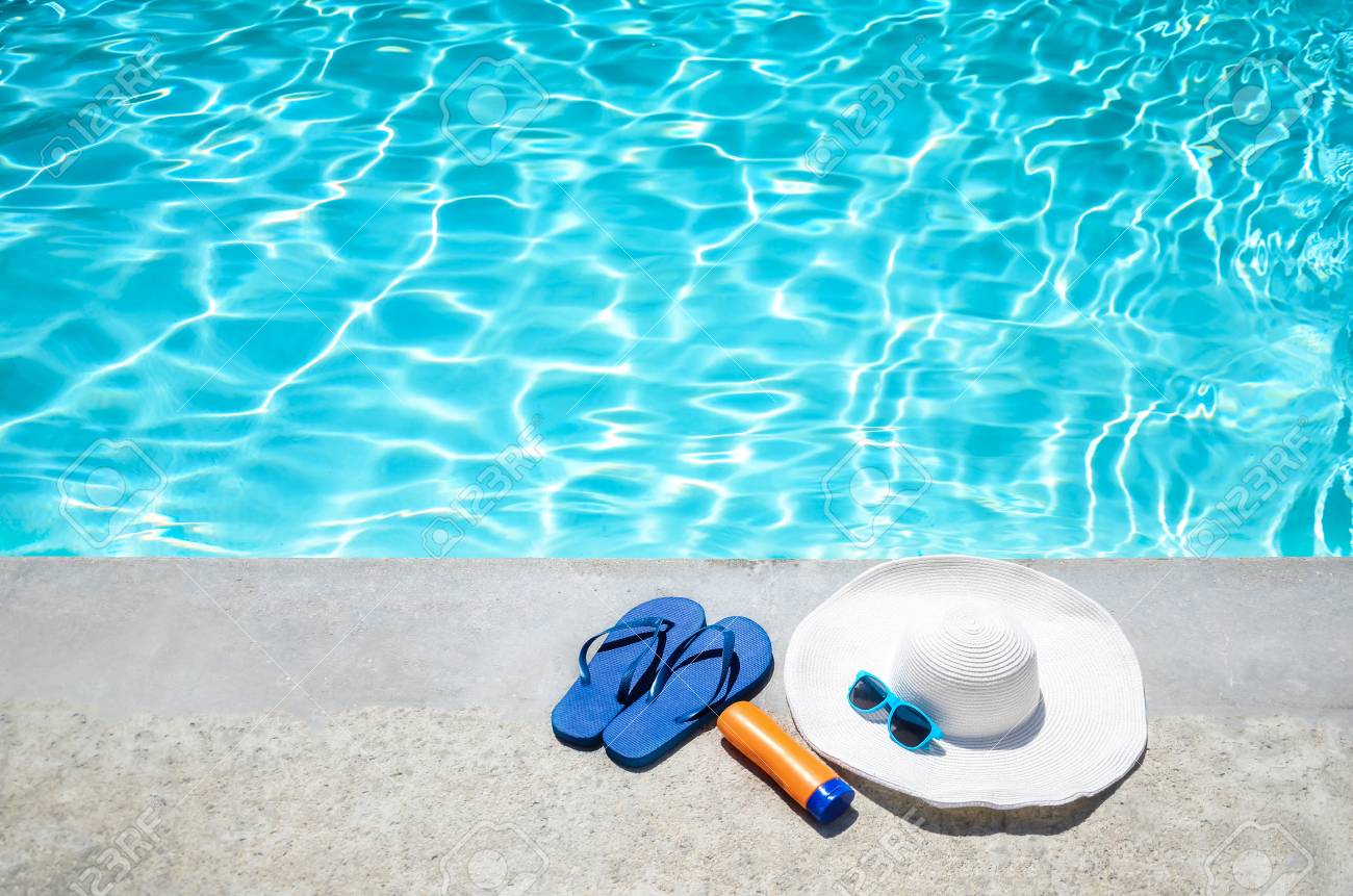 Summer background with hat, flip flops and sunglasses near the p Photo for the Sunscreen For Your Pool? blog post. Shop at Swimart.