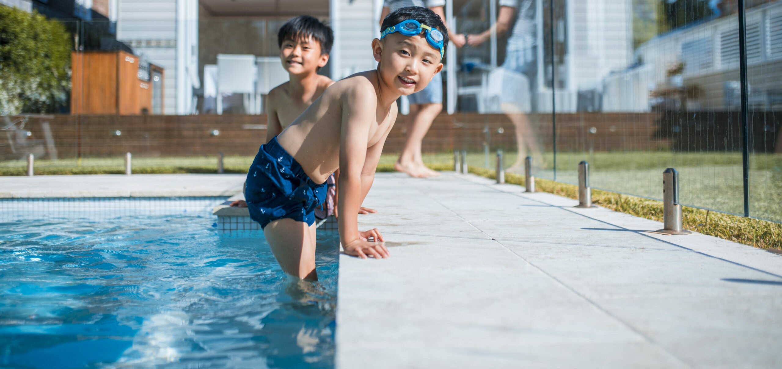 Photo of family having fun in the backyard pool. Kids are swimming.